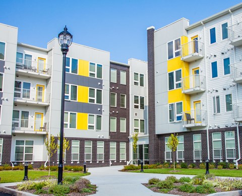a group of modern apartment buildings with a sidewalk